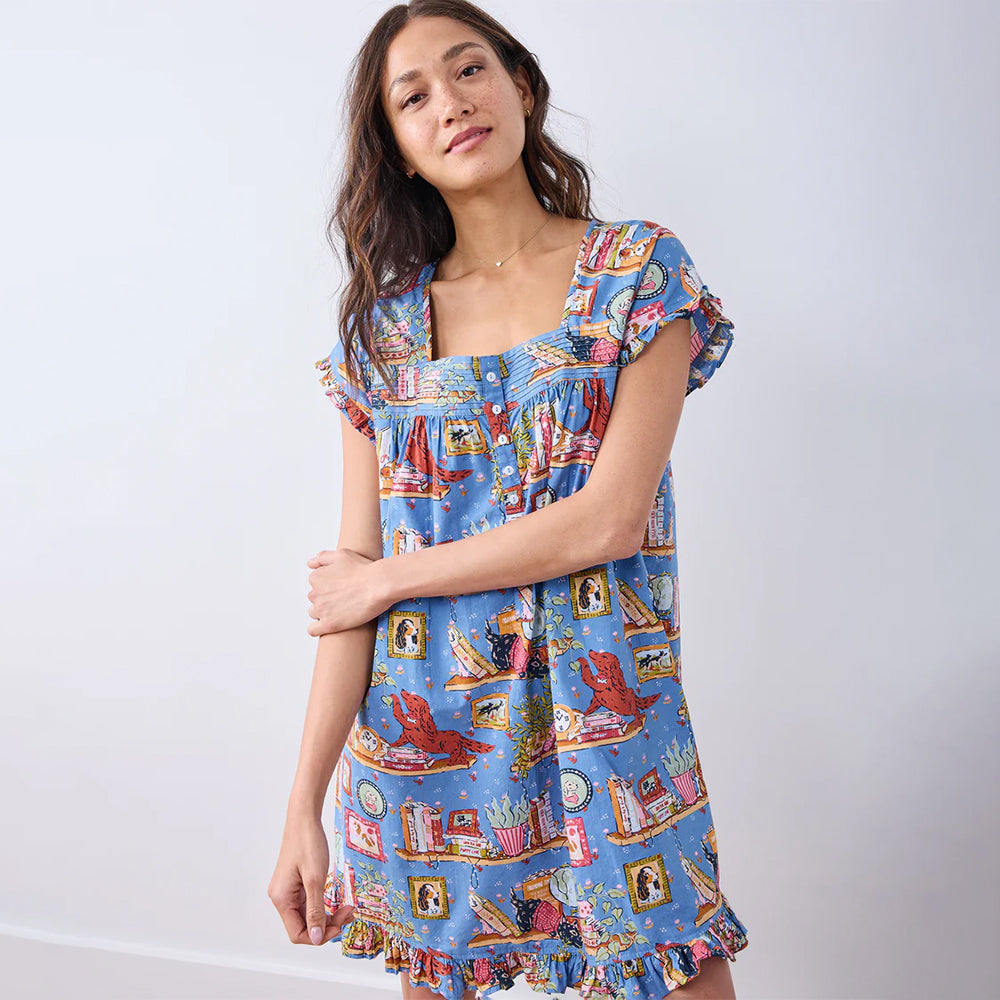 Woman wearing a colorful patterned dress against a white background