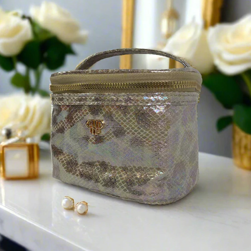 Snake print cosmetic bag on a table with flowers and perfume bottle in the background