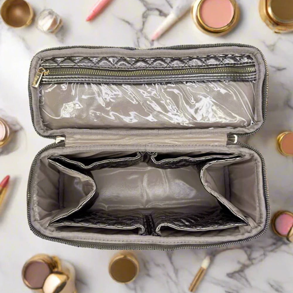 Open makeup bag with marble interior on a marble surface with makeup items around