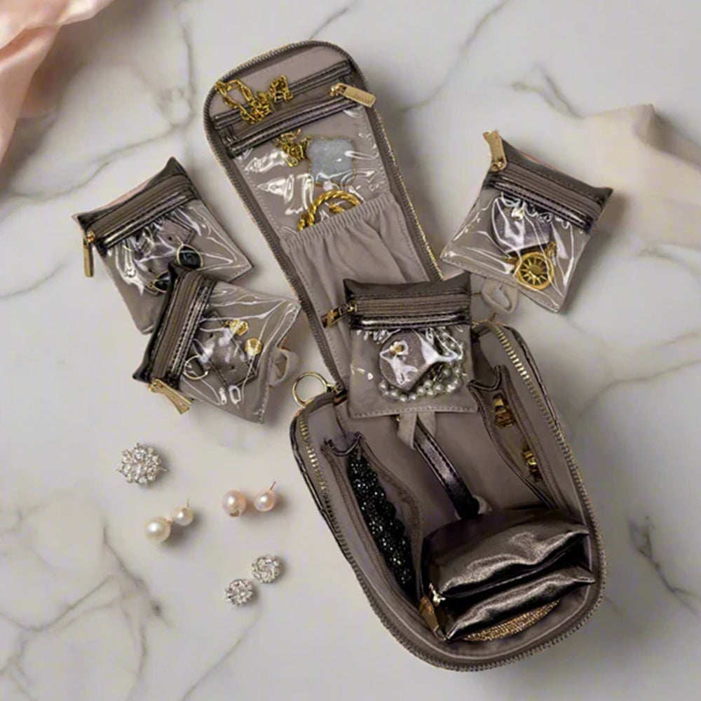Gray jewelry organizer with clear pouches on a marble surface