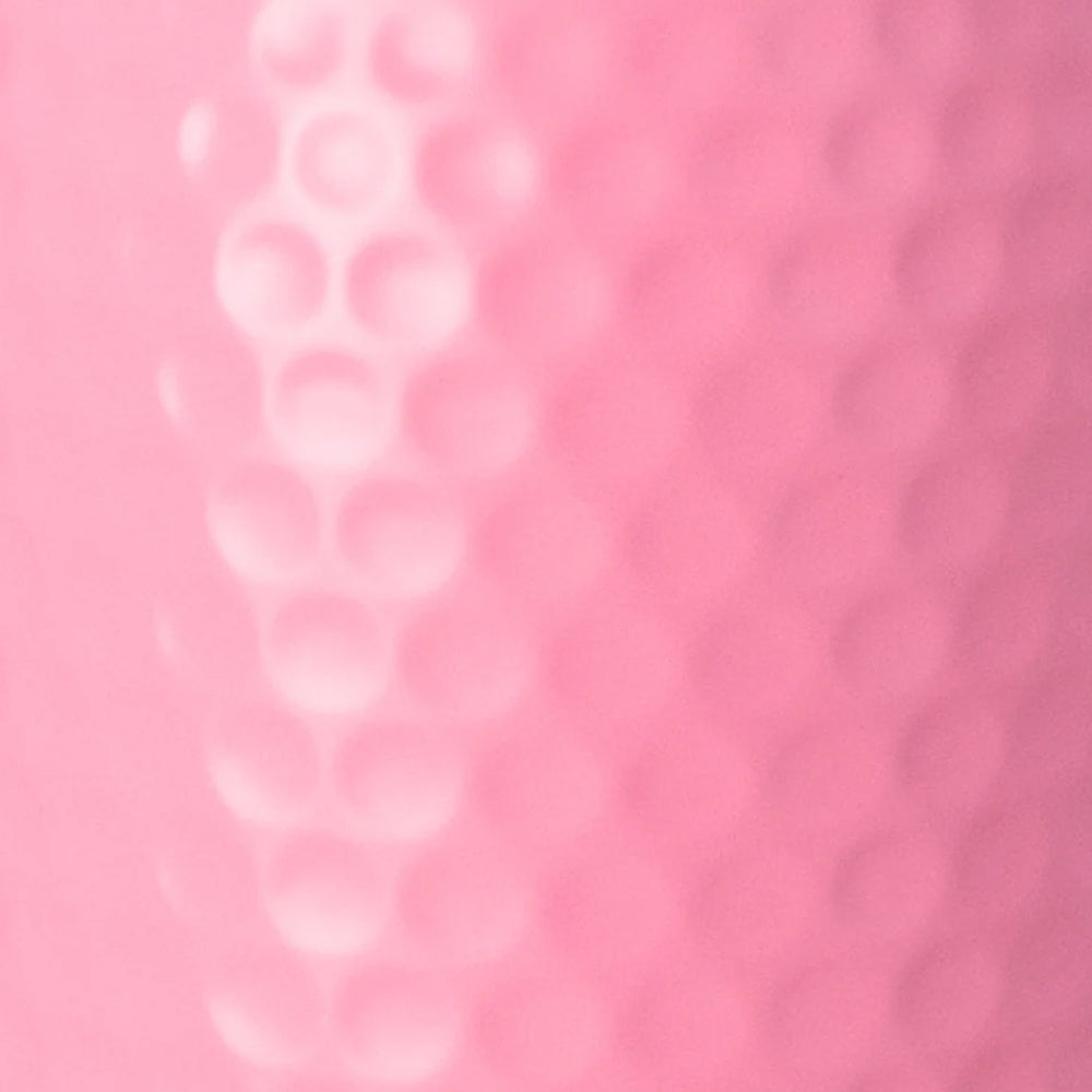 A close-up of a pink textured surface with a raised vertical row of circular dimples on the left and a smoother dotted pattern on the right.