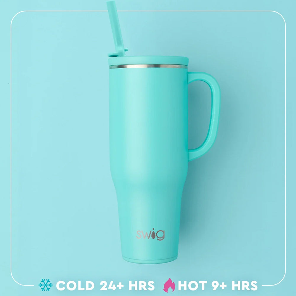 A mint green insulated travel tumbler with a handle, lid, and straw, featuring the 'swig' brand logo near the bottom. The tumbler is set against a matching light blue background with a white rounded border.
