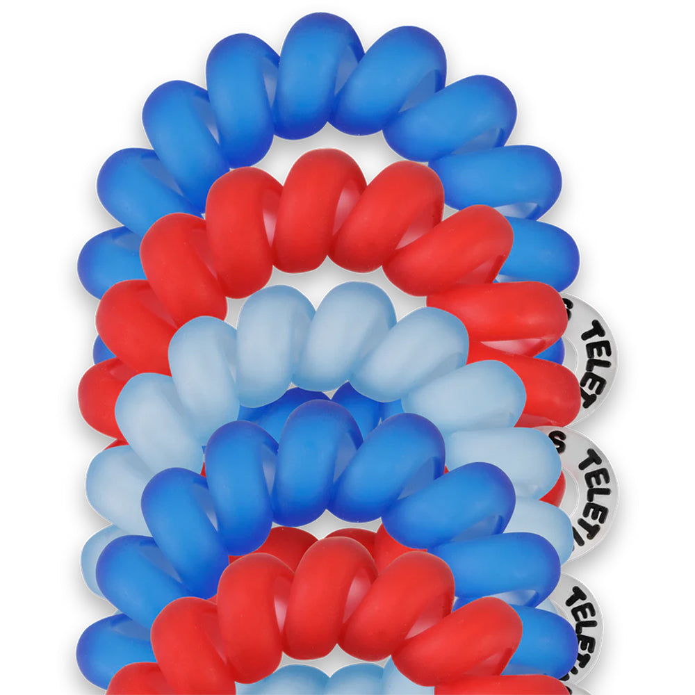 Red, white, and blue hair ties stacked on a white background