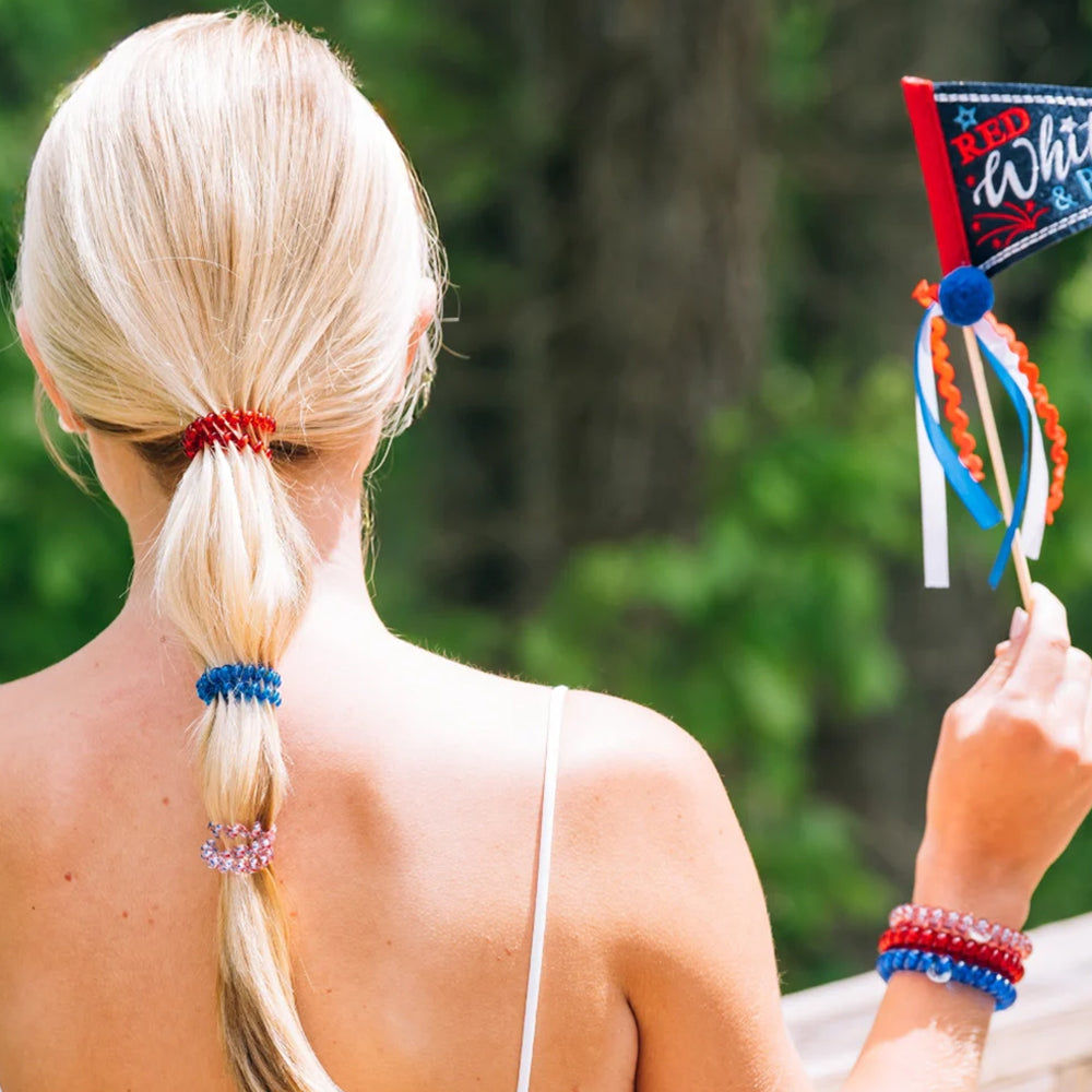 Person with a ponytail wearing colorful hair ties, holding a decorative item.