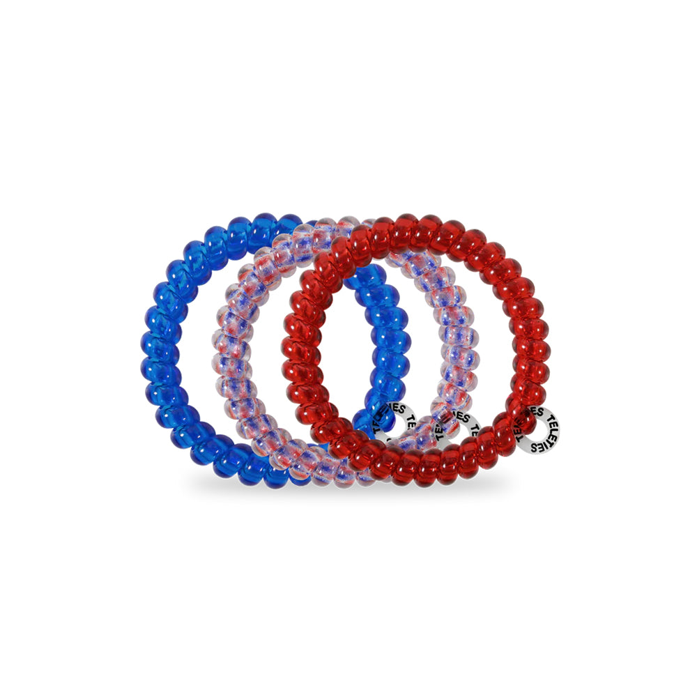 Set of three hair ties in blue, red, and clear on a white background