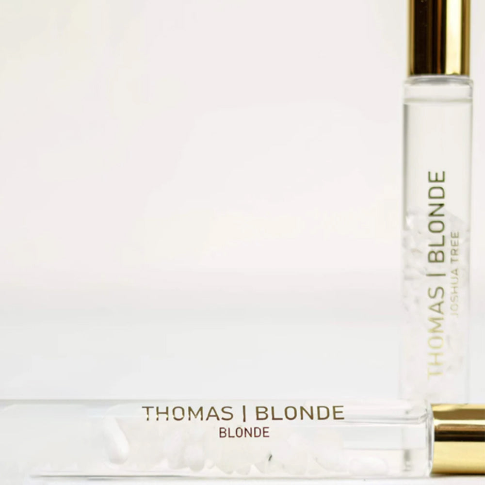Two bottles of Thomas Blonde perfume on a white background