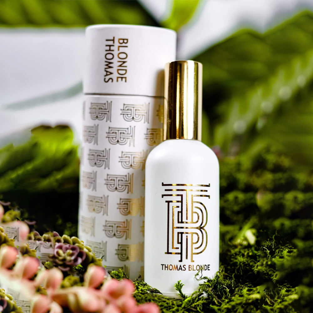 Two bottles of Thomas Blonde hair care products on a green leafy background