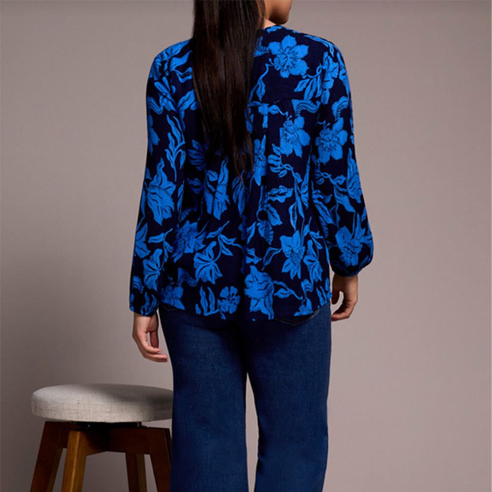 Person wearing a blue floral patterned against a plain background