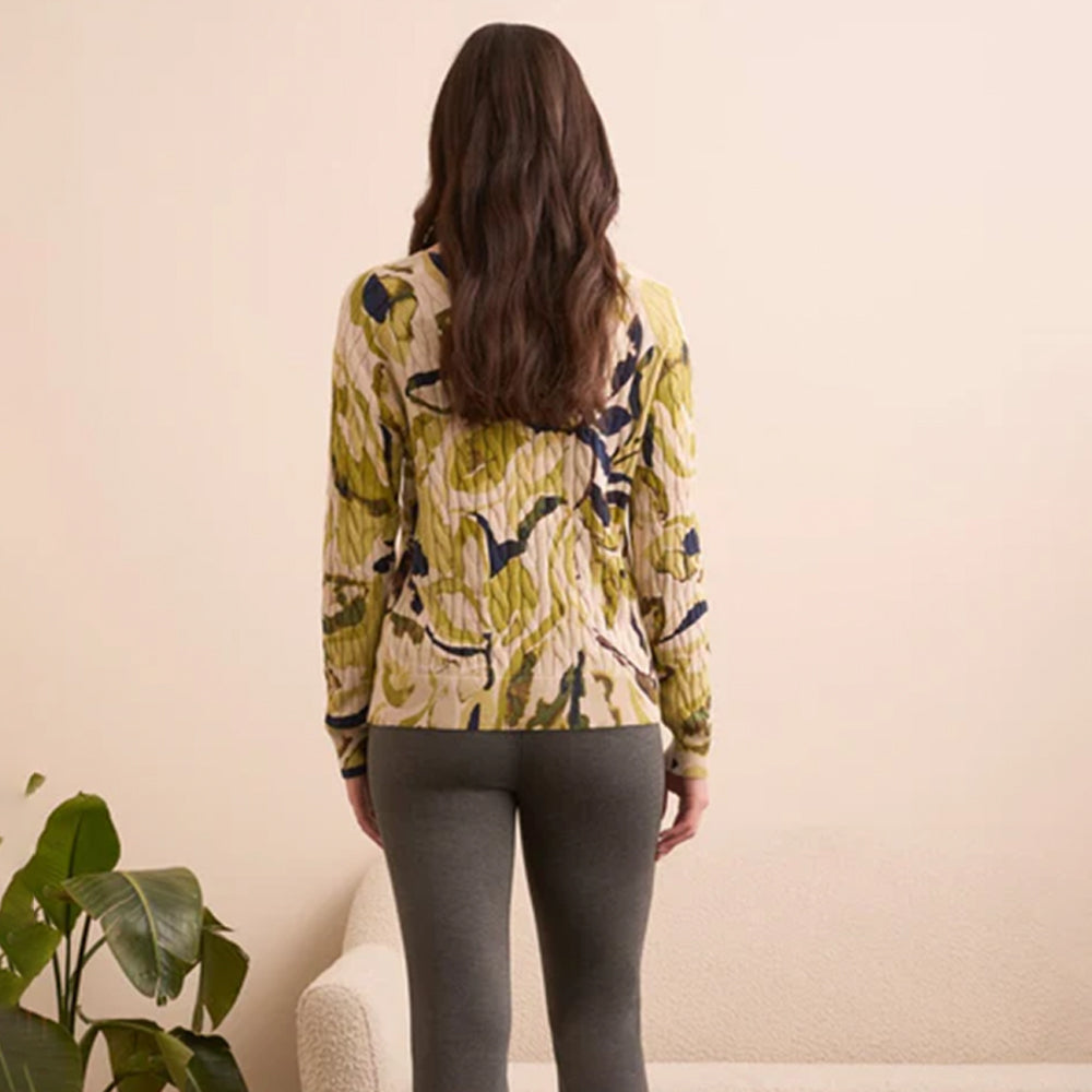 Woman wearing a patterned jacket in a minimal indoor setting