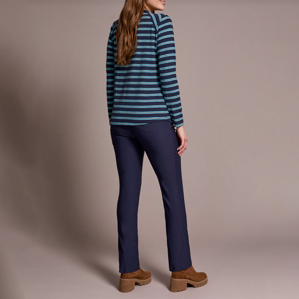 Person wearing a striped sweater and navy pants against a plain background