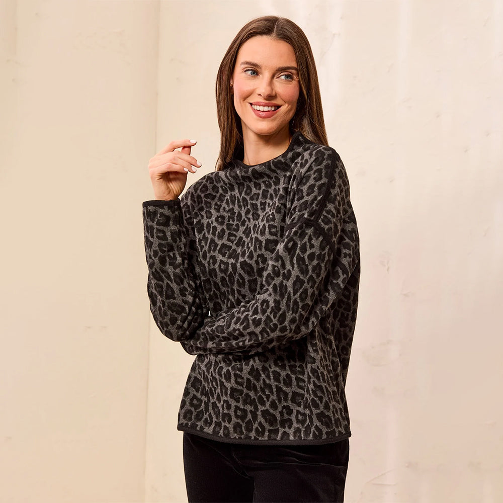 A woman modeling a black and gray leopard print long-sleeve top against a neutral beige background.