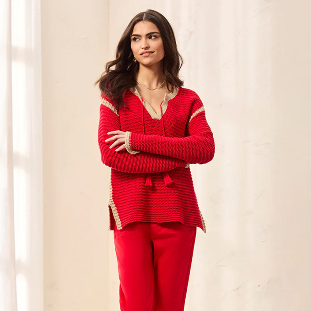 Woman wearing a red outfit with gold trim against a beige background
