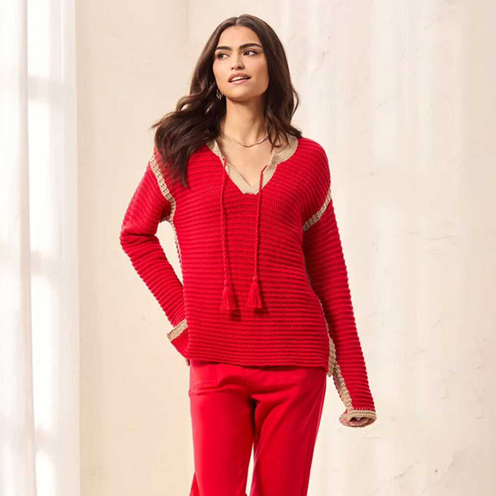 Woman wearing a red outfit with a textured top and pants against a light background