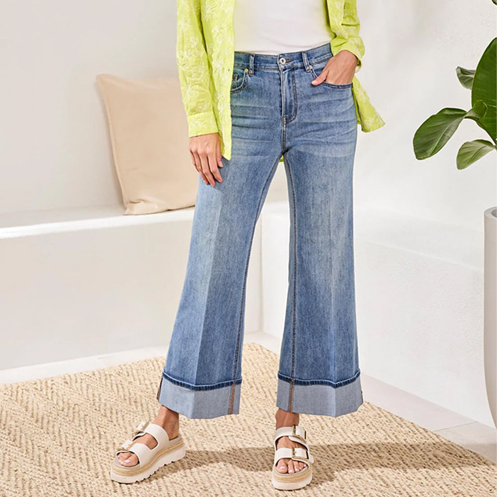 Person wearing blue jeans and a green jacket indoors