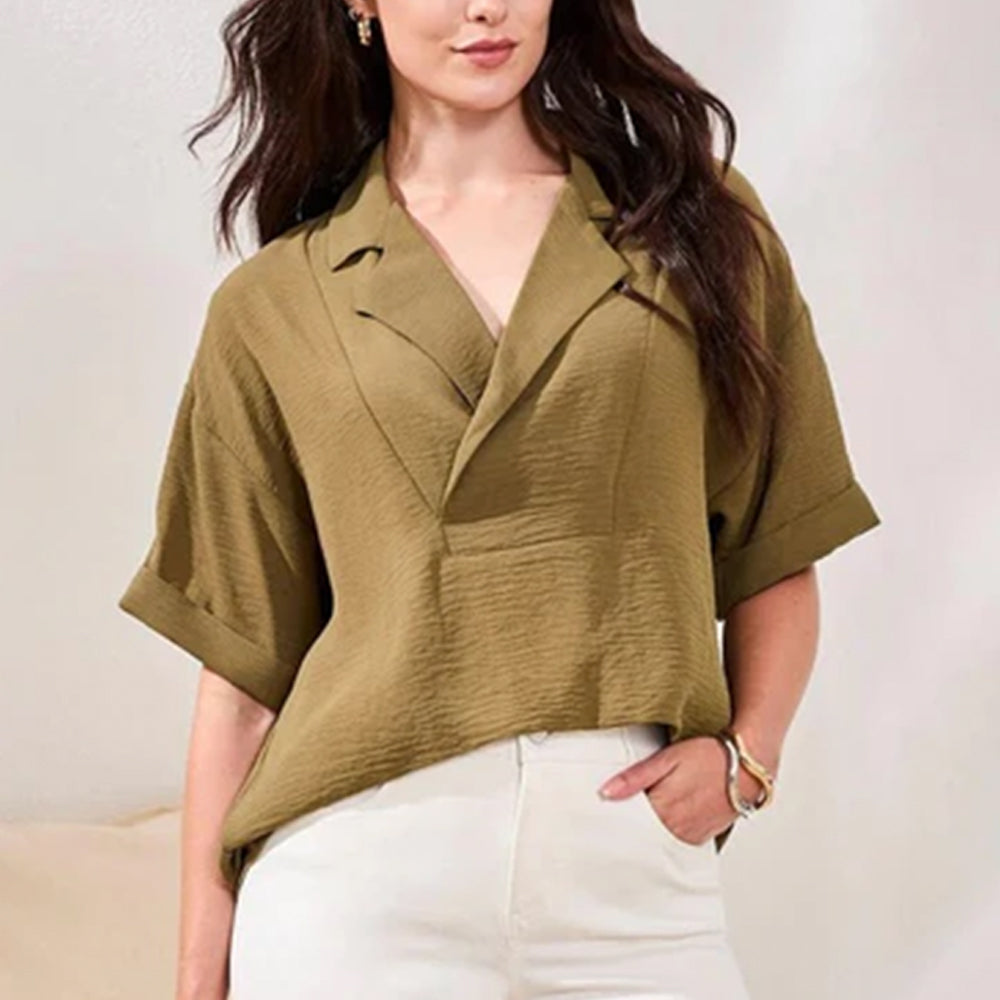 Woman wearing a green blouse with a plain background