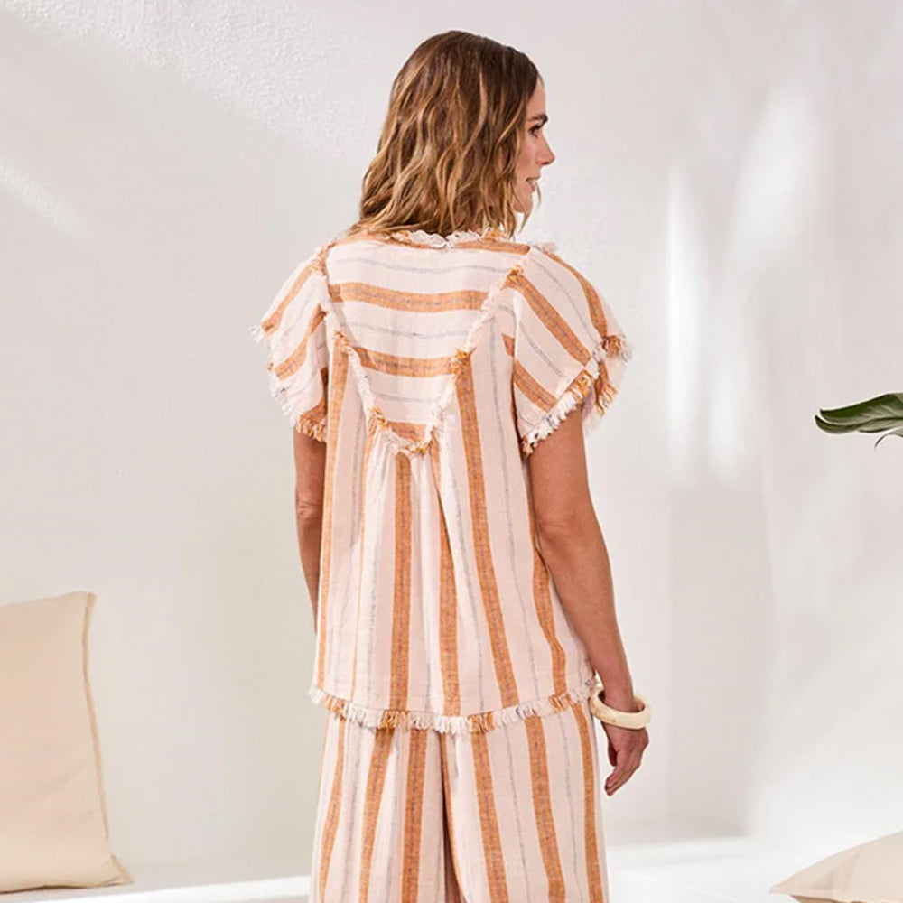 Woman wearing a striped outfit in a minimal indoor setting