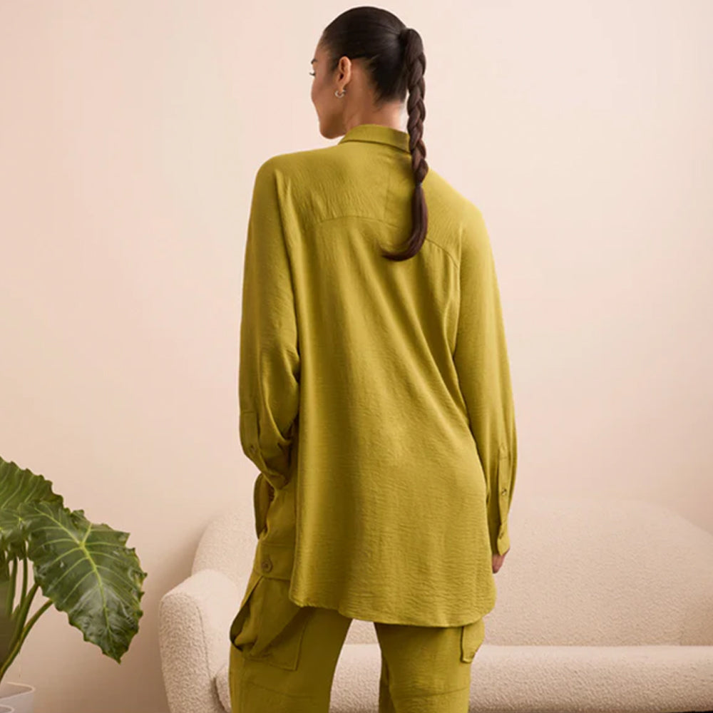 The back of a woman wearing a green button shirt.