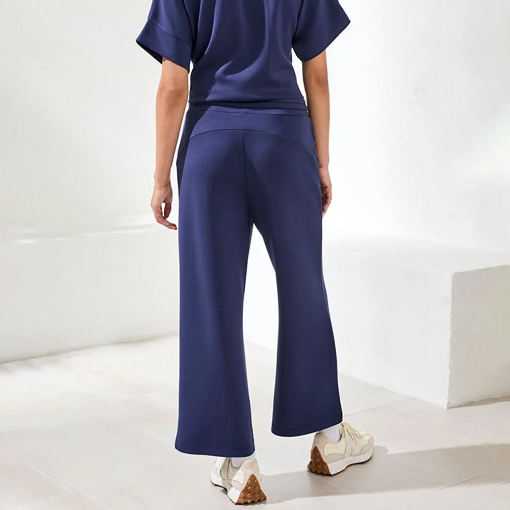Person wearing a navy outfit with wide-leg pants on a white background