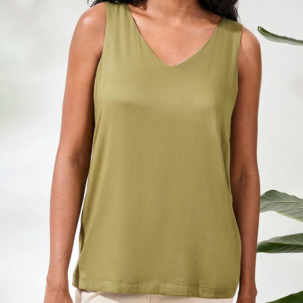 Person wearing a green tank top with a white background