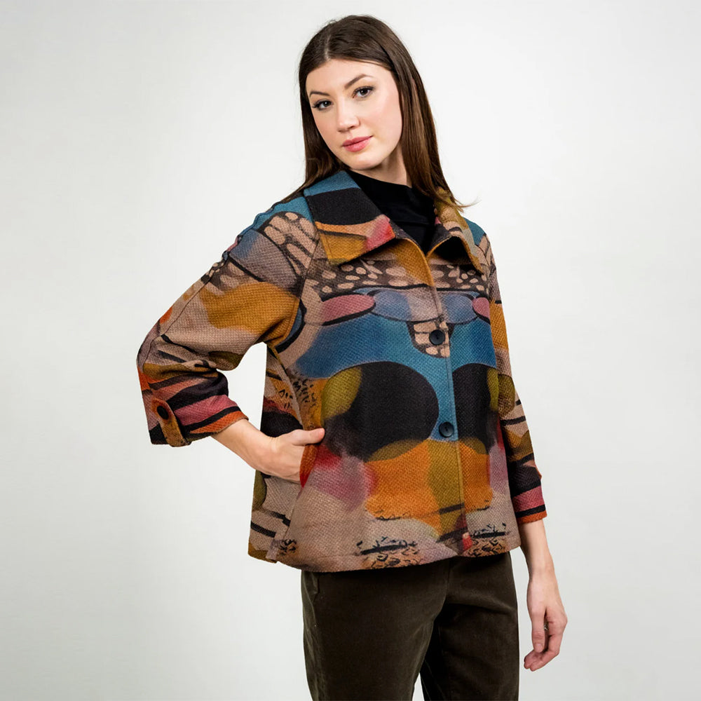 Woman wearing a colorful patterned jacket on a white background