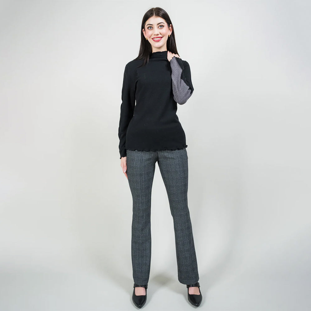 Woman wearing a black top and gray checkered pants on a white background