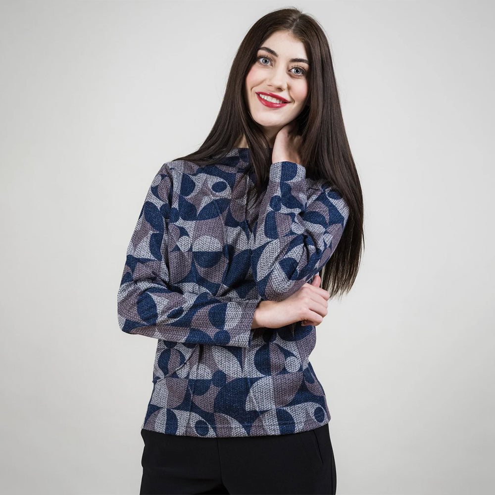 Woman wearing a patterned sweater against a plain background