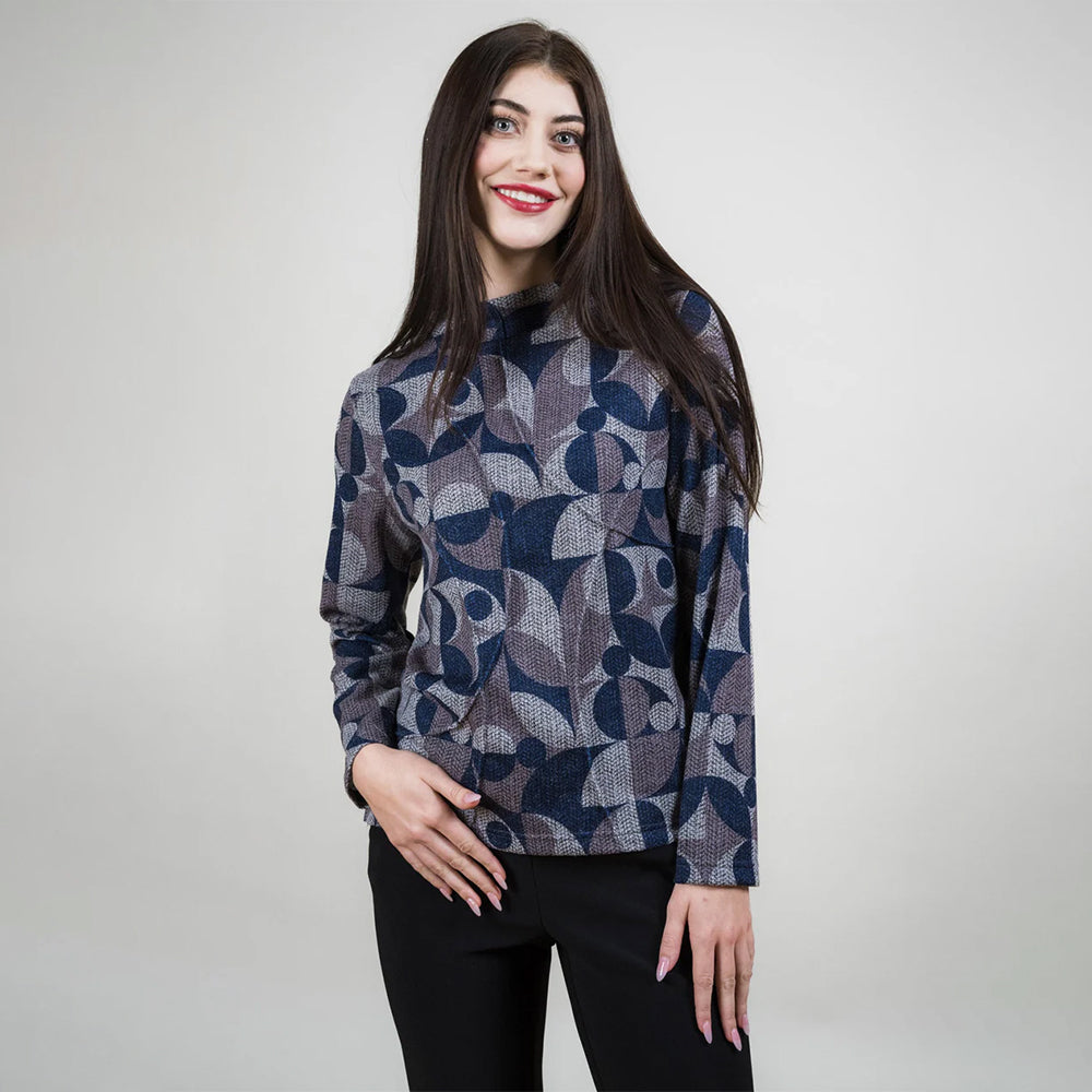 Woman wearing a patterned sweater against a plain background