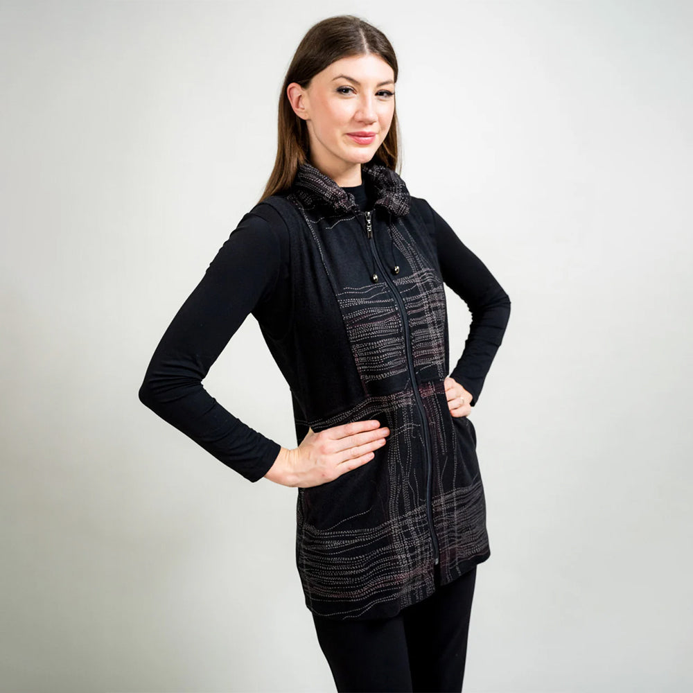 Woman wearing a black and plaid dress against a plain background