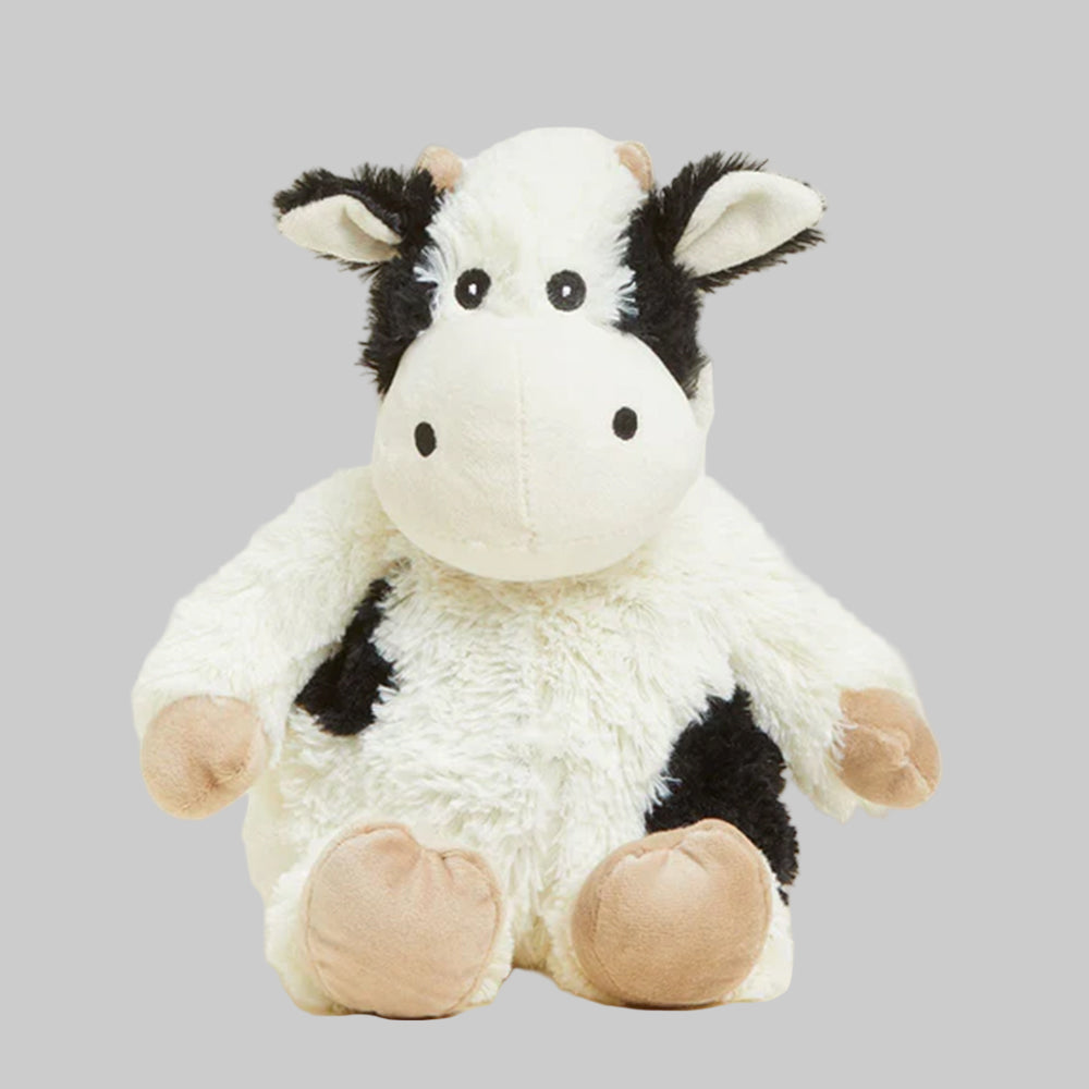 Plush cow toy on a gray background