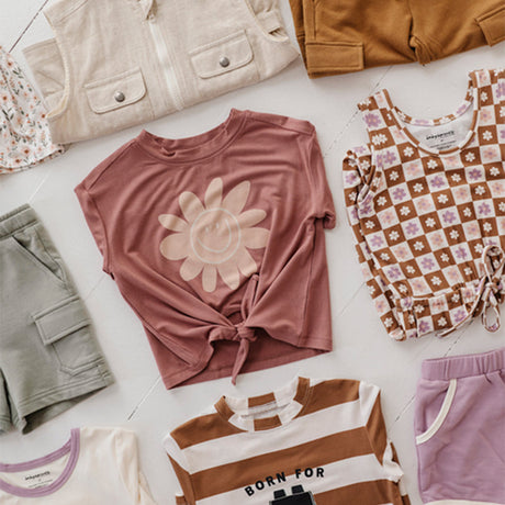 little girl with a beige vest and taupe flare leggings with long sleeve tee