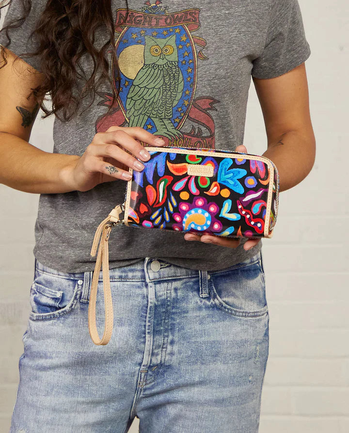 Girl wearing a grey t-shirt and blue jeans holding a Consuela wallet