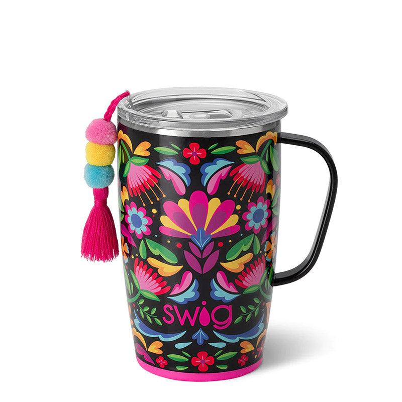 Swig mug with handle with a bright floral patter and a pink blue and yellow tassel hanging from the side. 