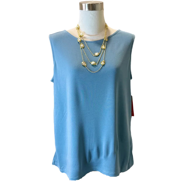 Mannequin wearing a blue sleeveless top with gold necklaces in front of a mirror.