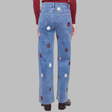 Blue jeans with floral embroidery on a white background