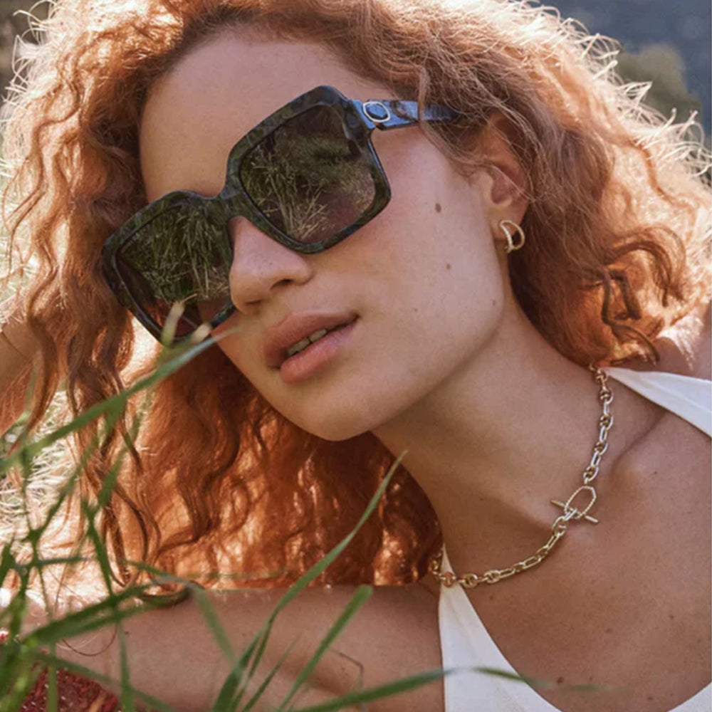 Woman wearing sunglasses with a blurred natural background