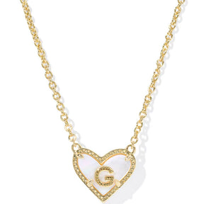 Gold necklace with a heart-shaped pendant featuring the letter 'G' on a white background