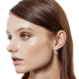 Close-up of a woman wearing a silver earring with a white background