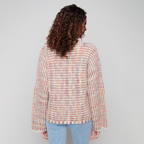 Person wearing a multicolored textured shirt against a plain background