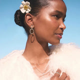 Woman with a flower in her hair against a clear blue sky