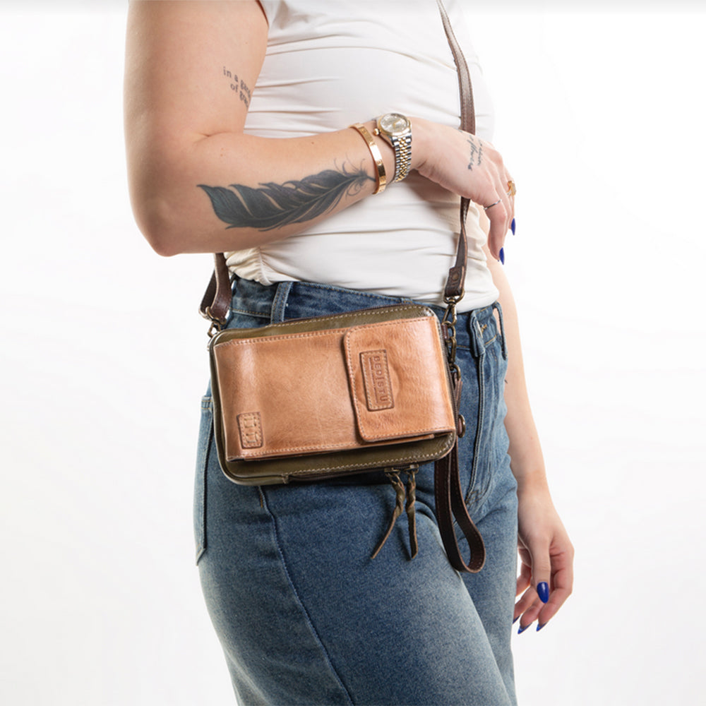 Person wearing a brown leather crossbody bag on a white background