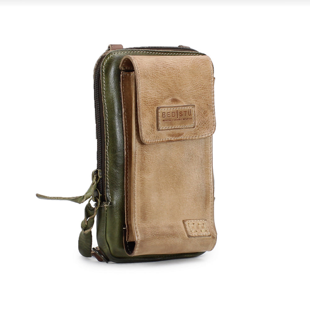 Brown leather crossbody bag with green strap on a white background