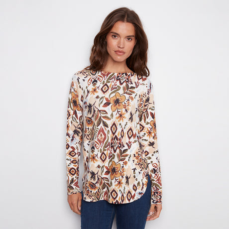 Woman wearing a patterned long-sleeve top on a plain background