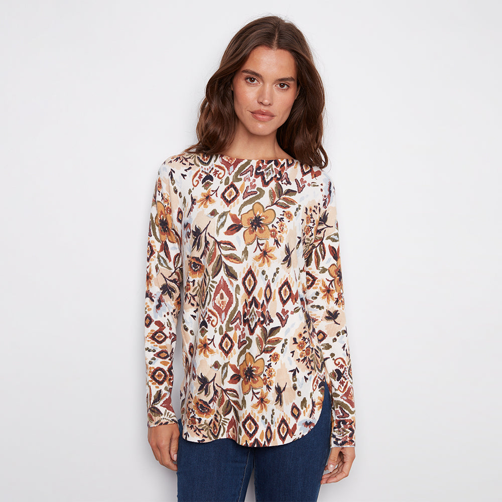 Woman wearing a patterned long-sleeve top on a plain background