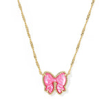 Necklace with a pink bow pendant on a gold chain against a white background