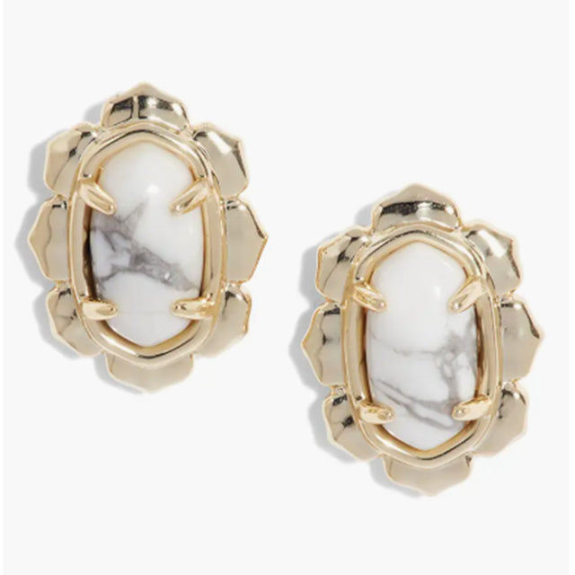 Gold-framed earrings with white stone centers on a white background