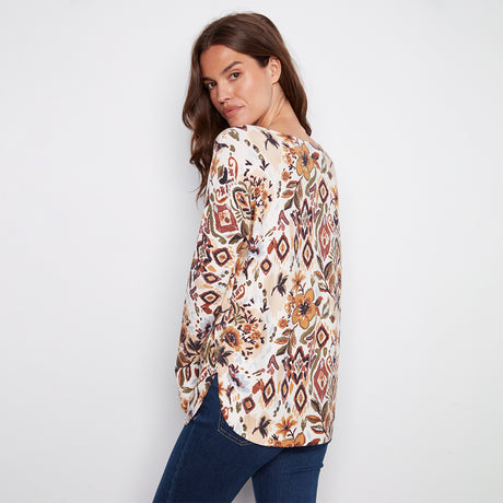 Woman wearing a patterned blouse with a plain background