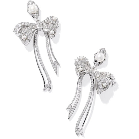 Silver bow-shaped earrings with pearls on a white background