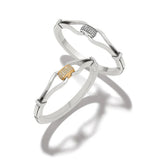 Two silver bracelets with gold accents on a white background
