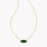 Gold necklace with a green gemstone pendant on a white background