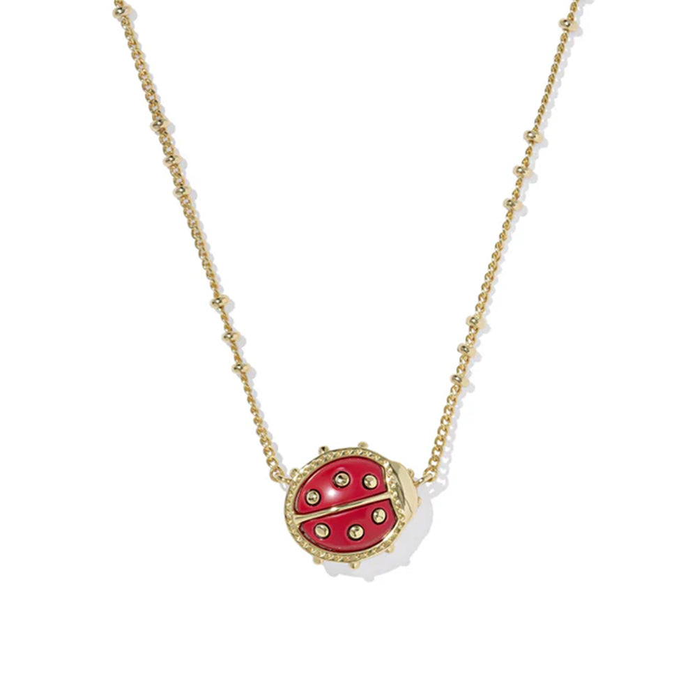 Red ladybug pendant necklace on a gold chain against a white background
